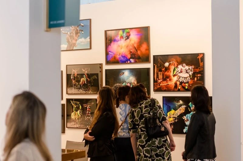 Visitantes observam obras fotográficas em um estande da ArtRio
