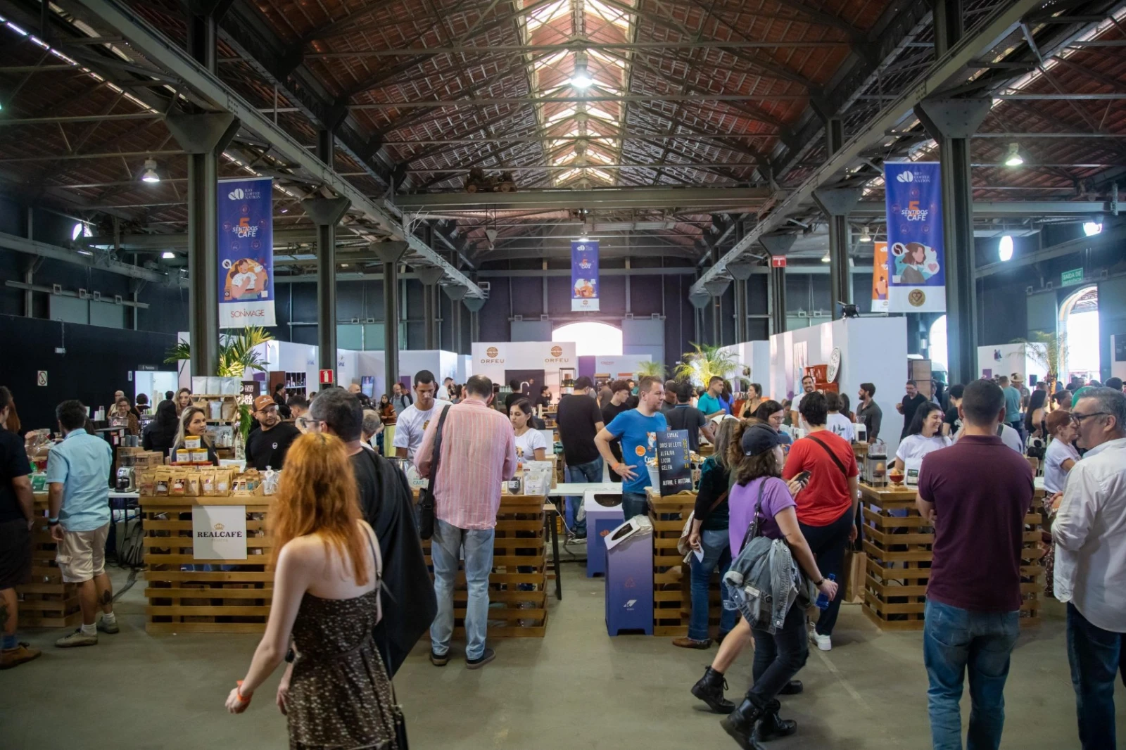 Visitors moving between roaster and coffee shop stands at a previous Rio Coffee Nation