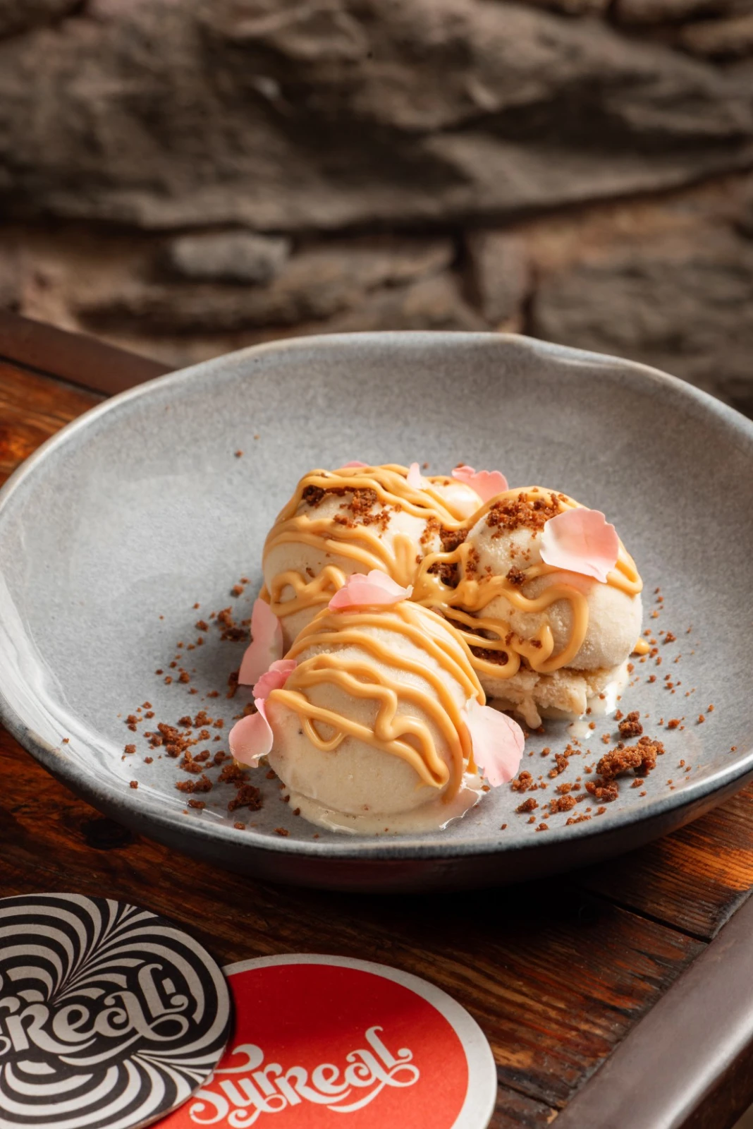 Gelato artesanal de banana del Surreal, con hilo de dulce de leche, crumble y pétalos