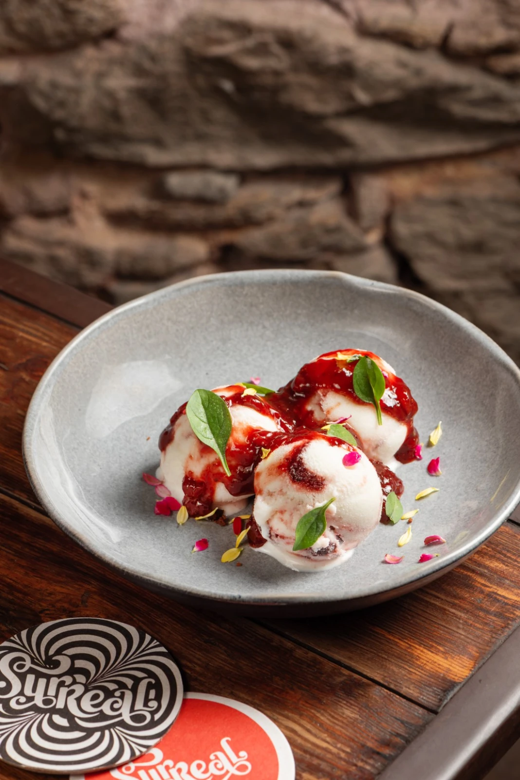 Gelato artesanal de yogur con frutos rojos del Surreal, con salsa de frutas y hojas frescas